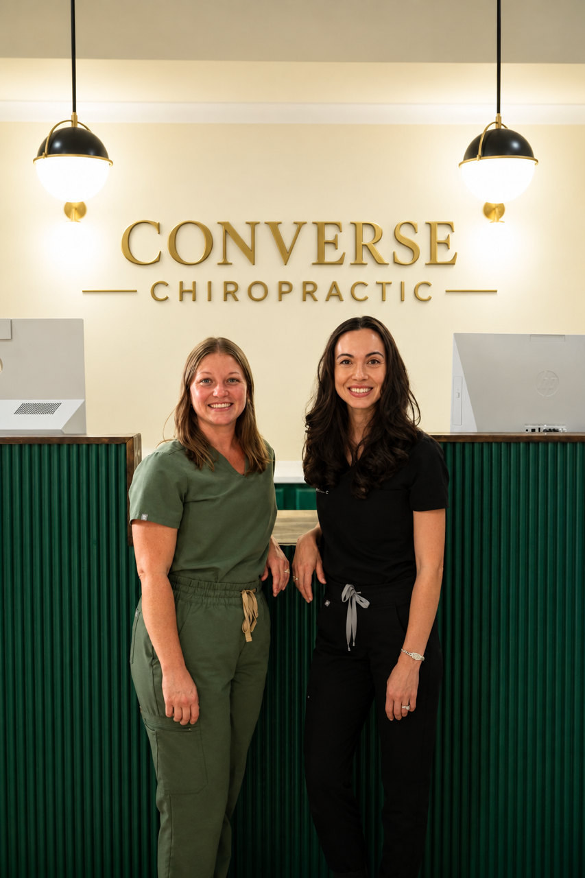 Dr. Christy Rody and a team member smiling at the Converse Chiropractic front desk in Spartanburg, SC